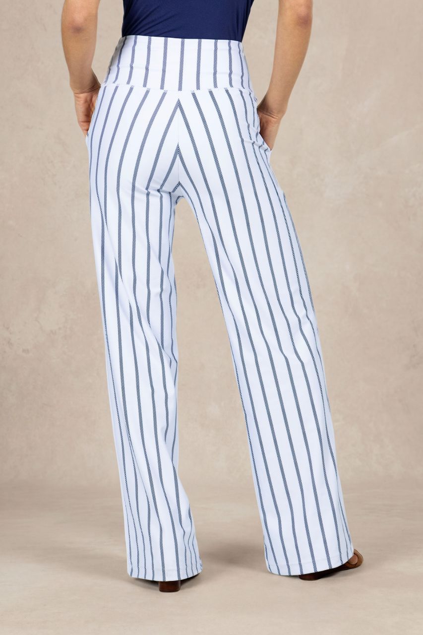 Person wearing white pants with blue stripes on a beige background