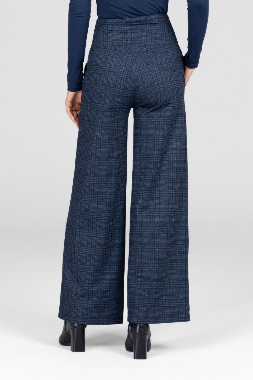 Back view of a woman wearing navy plaid wide-leg pants worn by a person on a white background