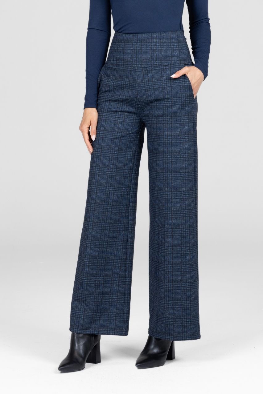 Woman wearing blue plaid pants with a white background