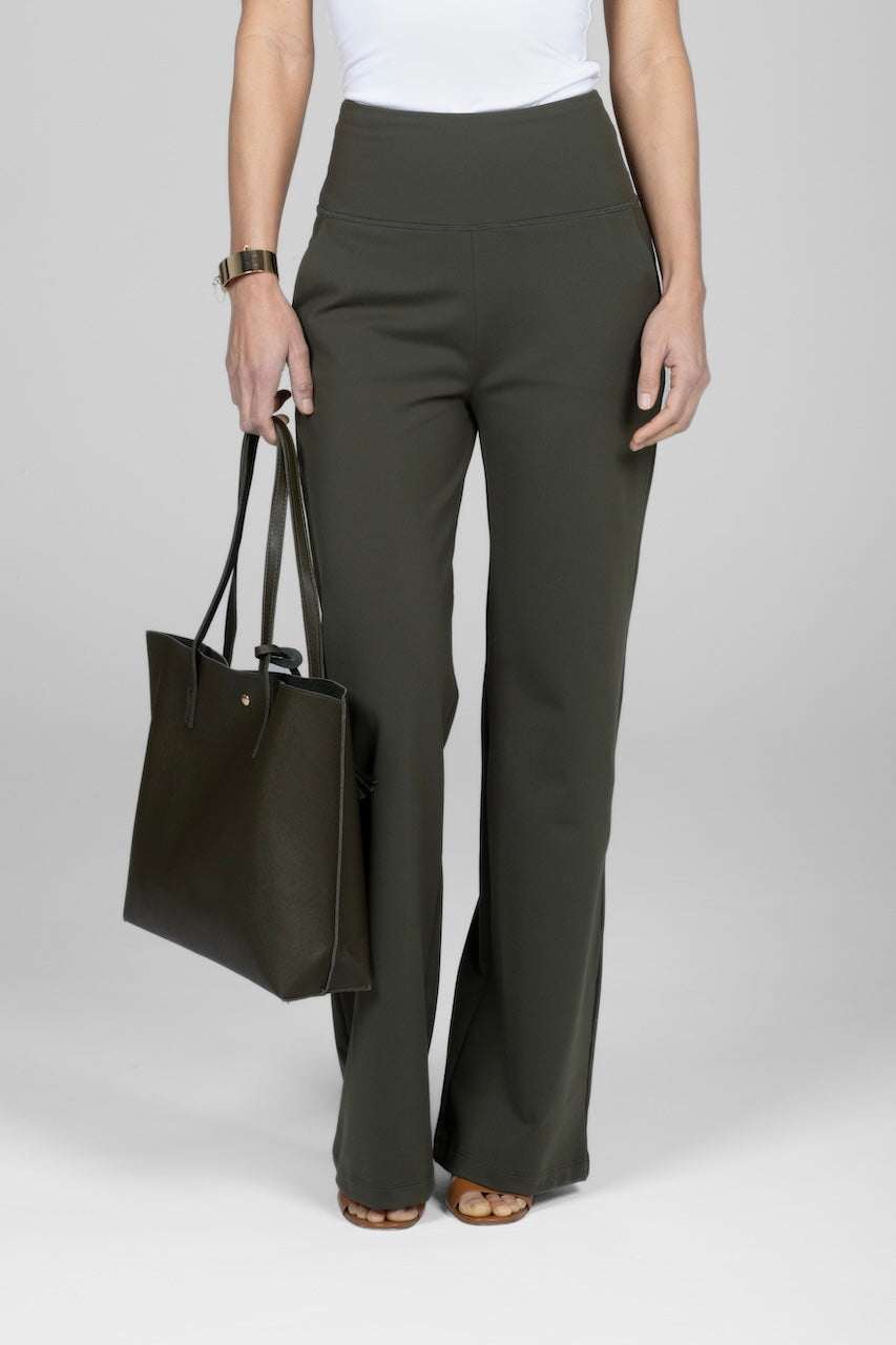 A person wearing high waisted wide leg forest green pants and a white top