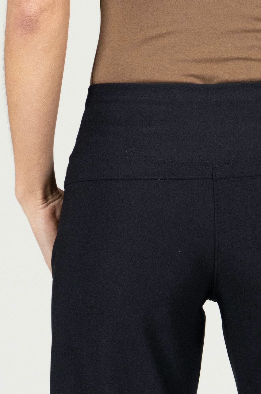 Close-up of the High Rise Wide Leg Traveler Pant in black, highlighting the luxurious fabric texture and the sleek waistband detail