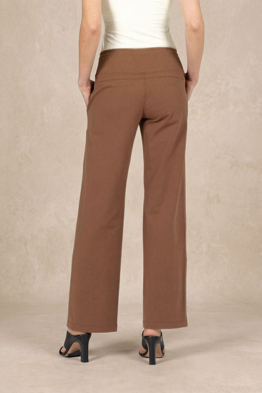 Brown pants worn by a person on a beige background