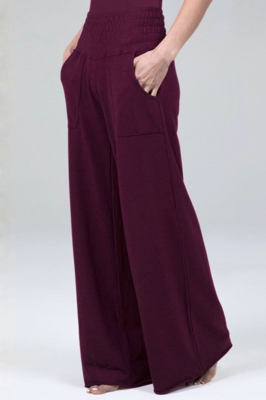 Burgundy wide-leg lounge pants worn by a woman on a white background
