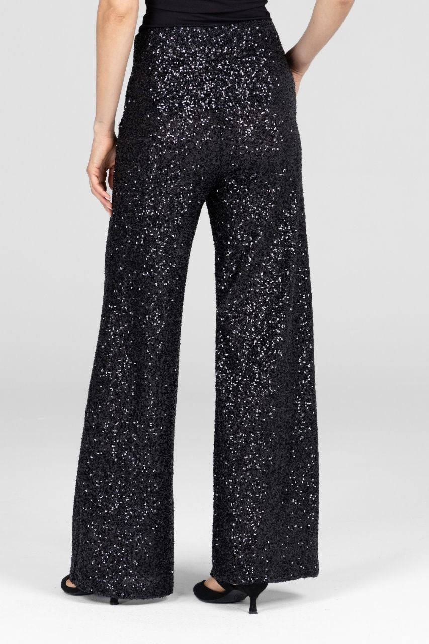 Back view of black sequin pants worn by a woman on a white background