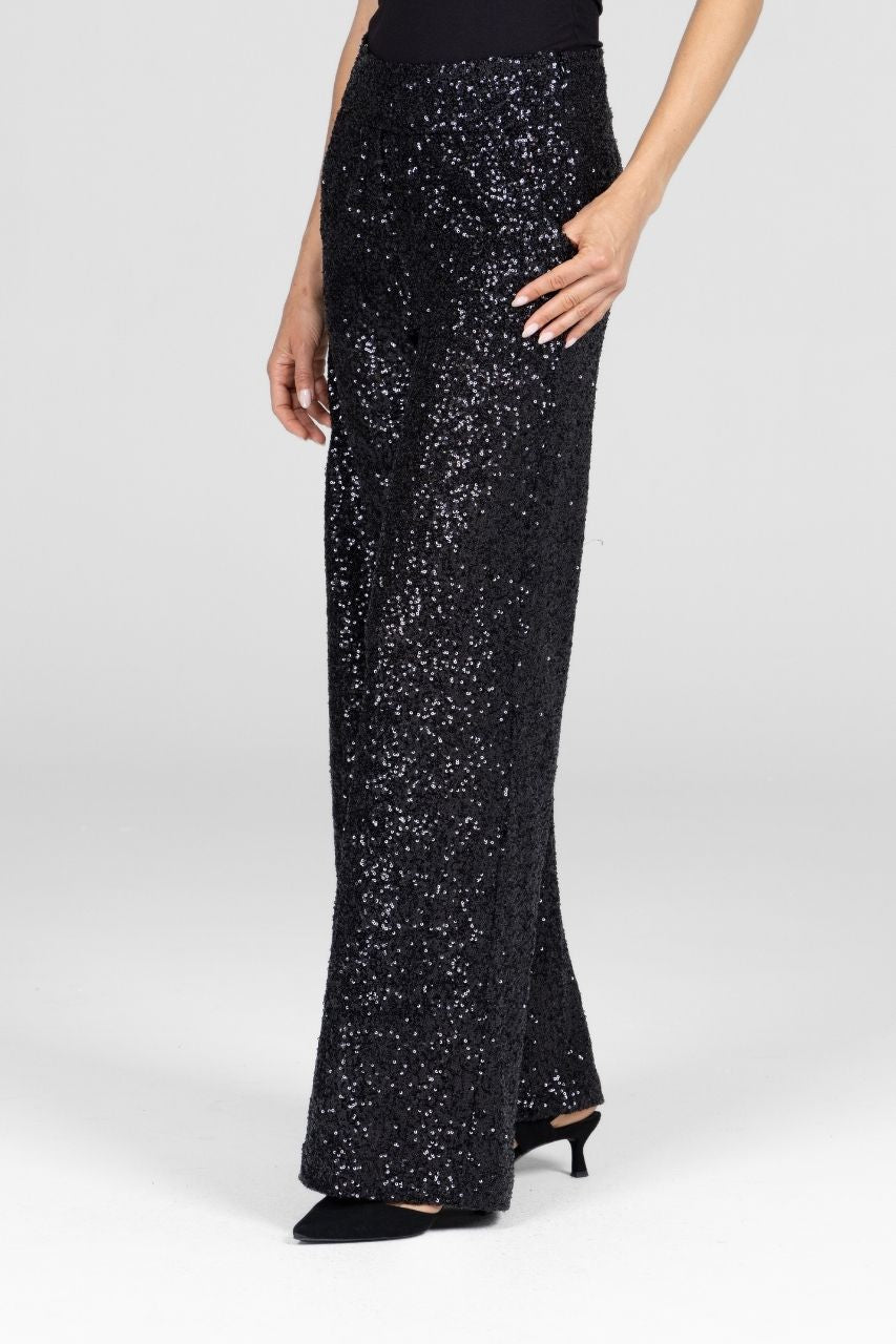 Woman wearing black sequin wide leg pants on a white background