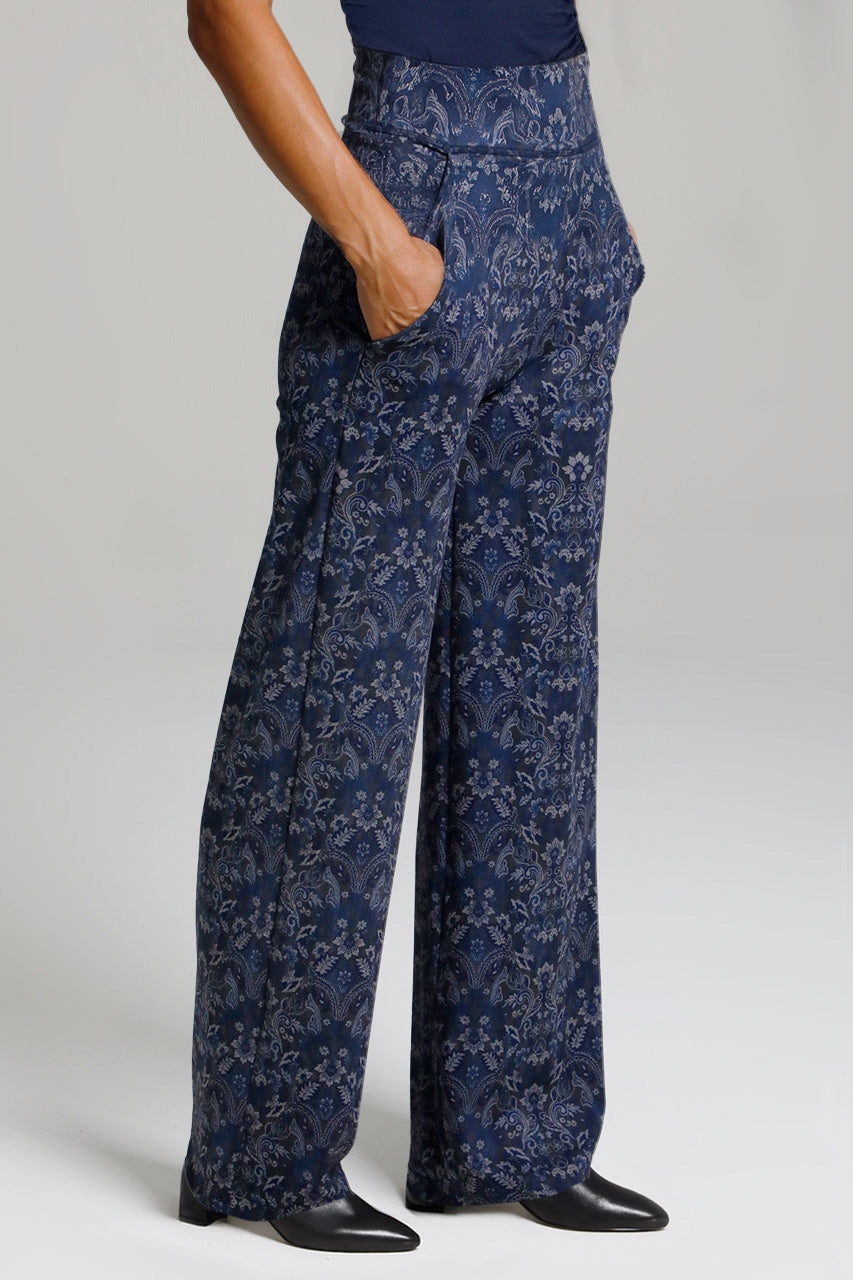 Navy floral-patterned wide leg pants worn by a person on a light gray background