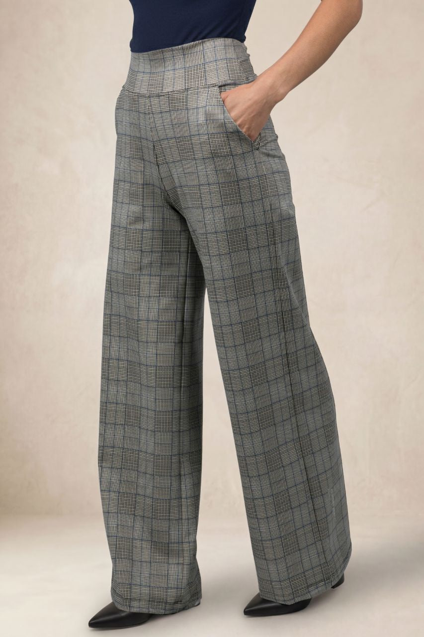 Person wearing plaid high waist wide leg pants on a beige background