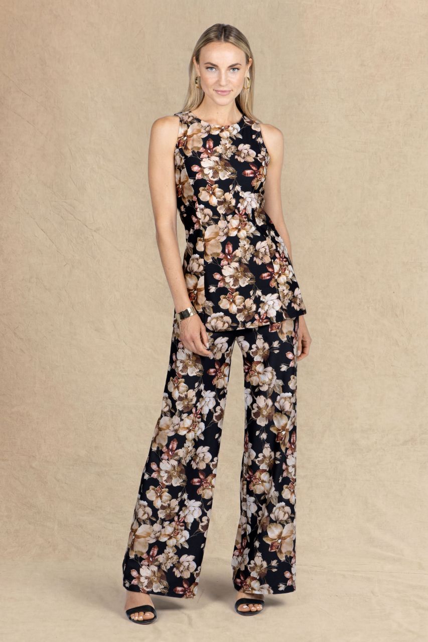 Woman wearing a full fall floral matching outfit with a tunic and wide leg pants on a beige background