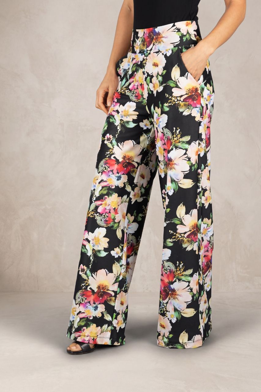 Floral pants worn by a person on a neutral background