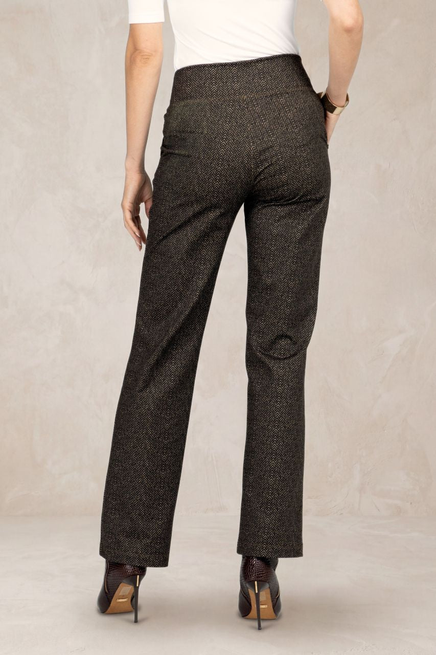Back view of brown herringbone pants worn by a person on a plain background