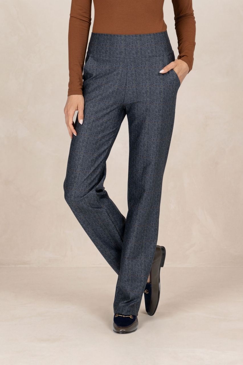 Woman wearing grey tartan straight leg pants on a beige background