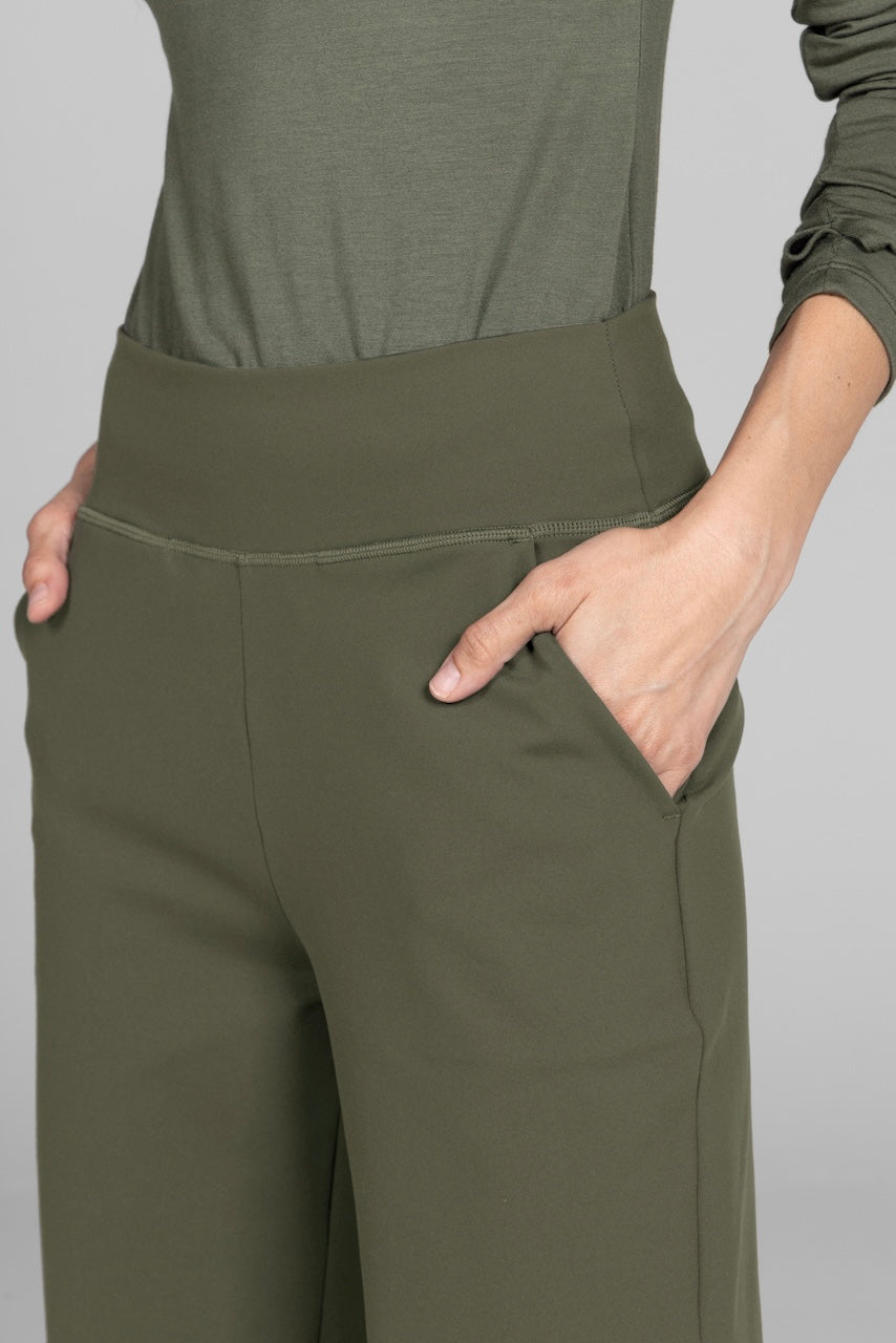 Close-up of olive high-waisted pants with hand in side pocket.