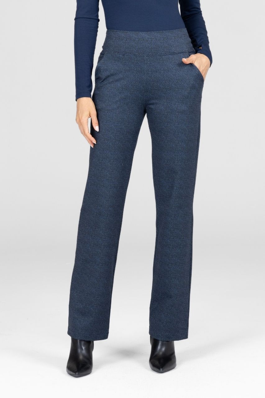 Woman wearing blue tweed straight leg pants and a navy top on a white background