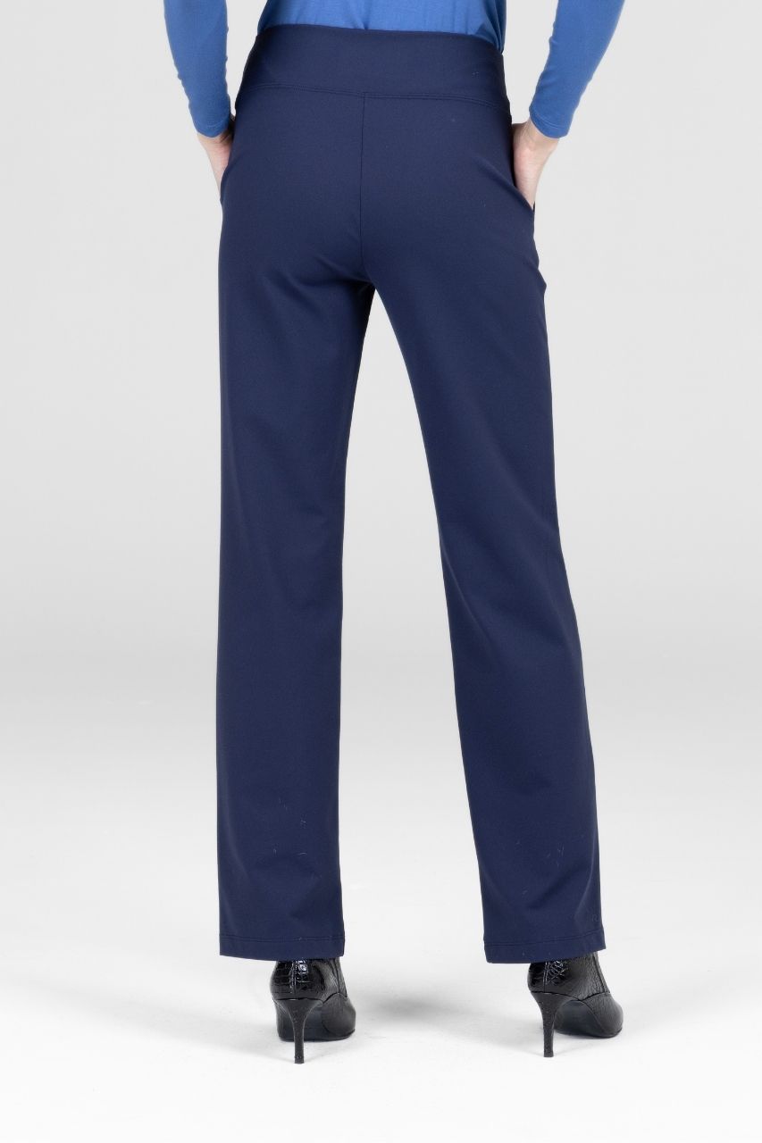 Back view of woman wearing navy blue straight leg dress pants worn by a person on a white background