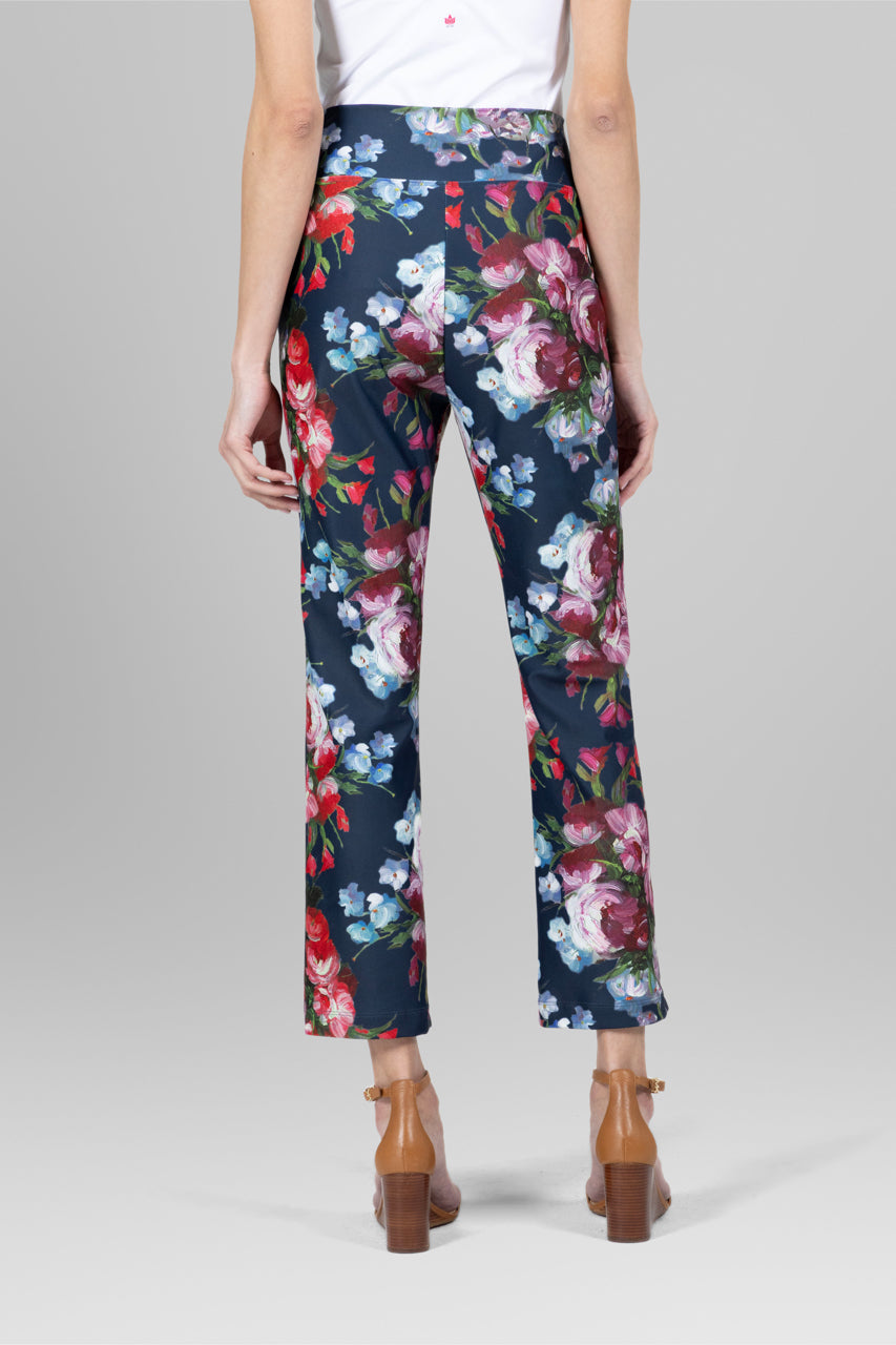 Back view of a model wearing a white top paired with the High Waist Ankle Kick Pant in spring floral, highlighting the flattering fit and vibrant floral pattern from behind