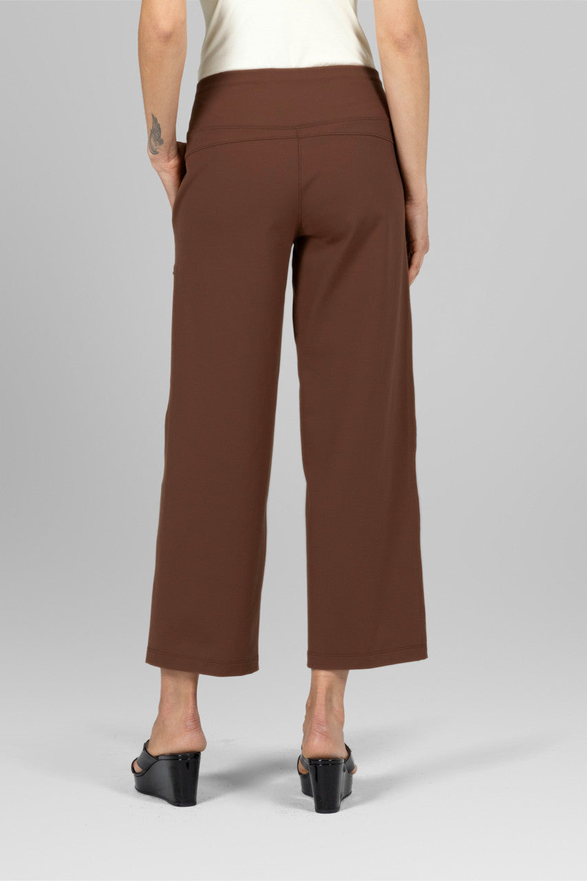 Back view of the Traveler Ankle Pant in dark khaki, showcasing the flattering fit and stylish design from behind