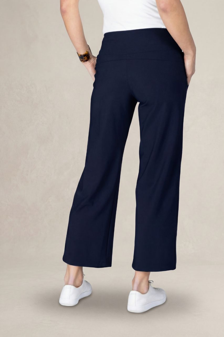 Navy blue cropped pants worn by a person on a beige background