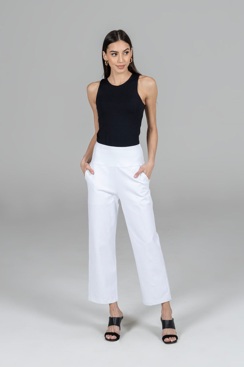 Model posing in a black tank top in HIGH WAIST ANKLE PANT: WHITE