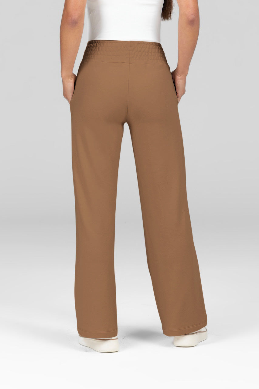 Back view of light brown mid-rise terry wide leg pants with  a smocked waistband