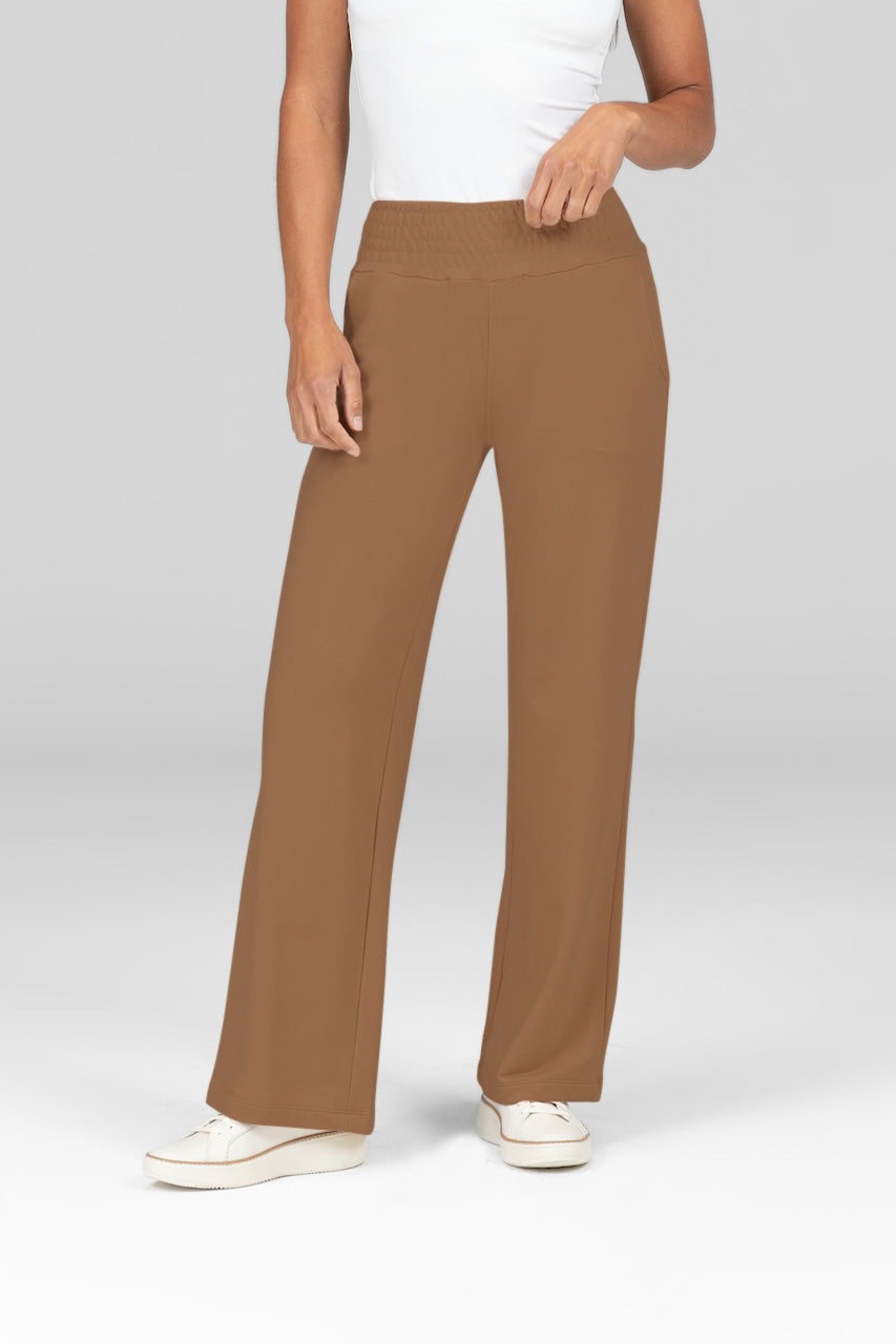 Model wearing mid-rise terry sweatpants with smocked waistbands and wide leg with a white tank top