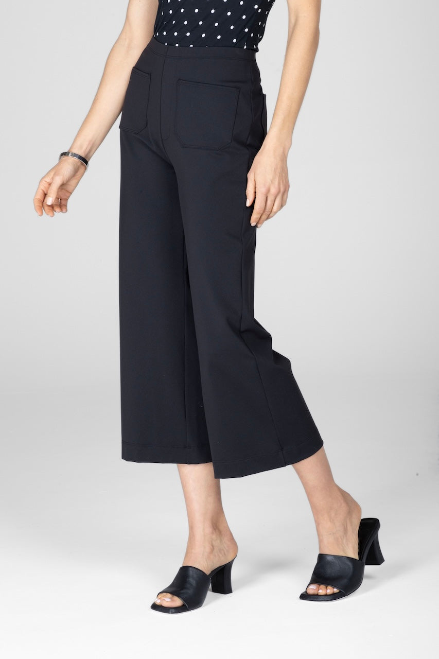 Woman wearing black cropped pants with front patch pockets
