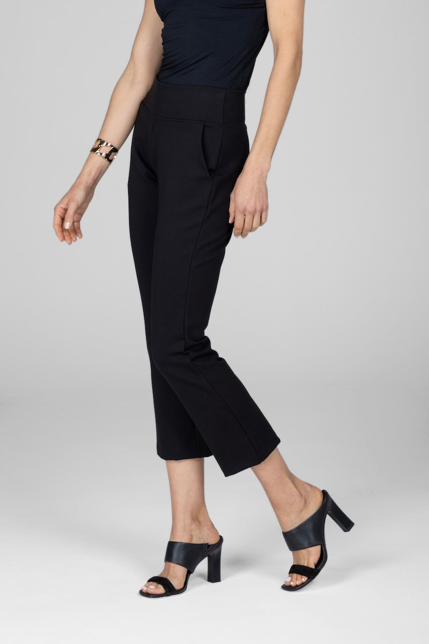 Side view of woman wearing black high waist ankle kick dress pant with front pockets