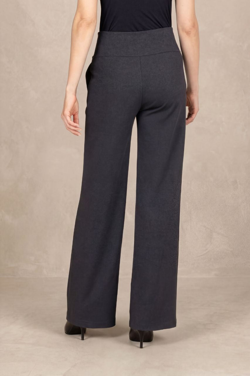 Back view of a person wearing dark gray wide-leg pants on a beige background