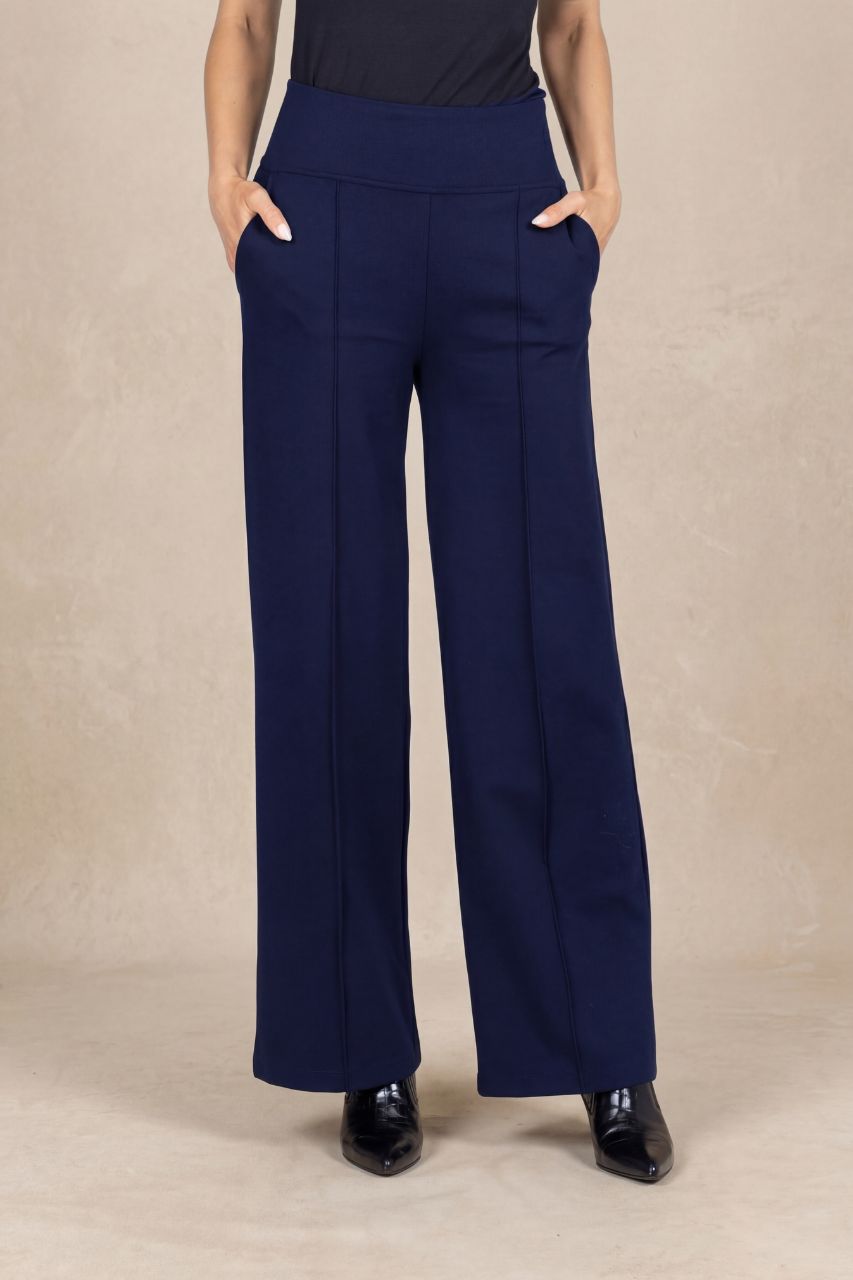 Navy blue wide-leg pants with pintucks worn by a person on a beige background