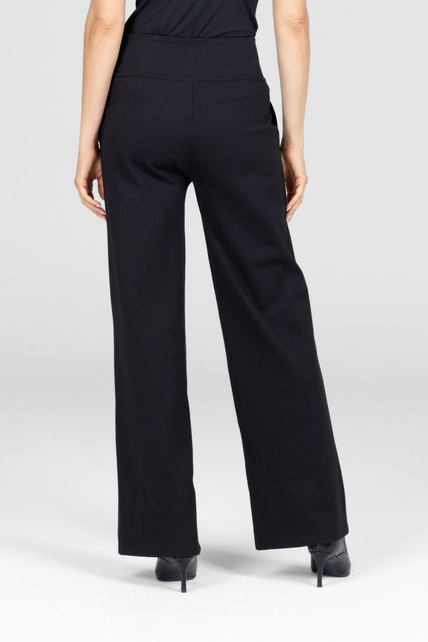 Back view of a woman wearing black wide-leg pants worn by a woman on a white background