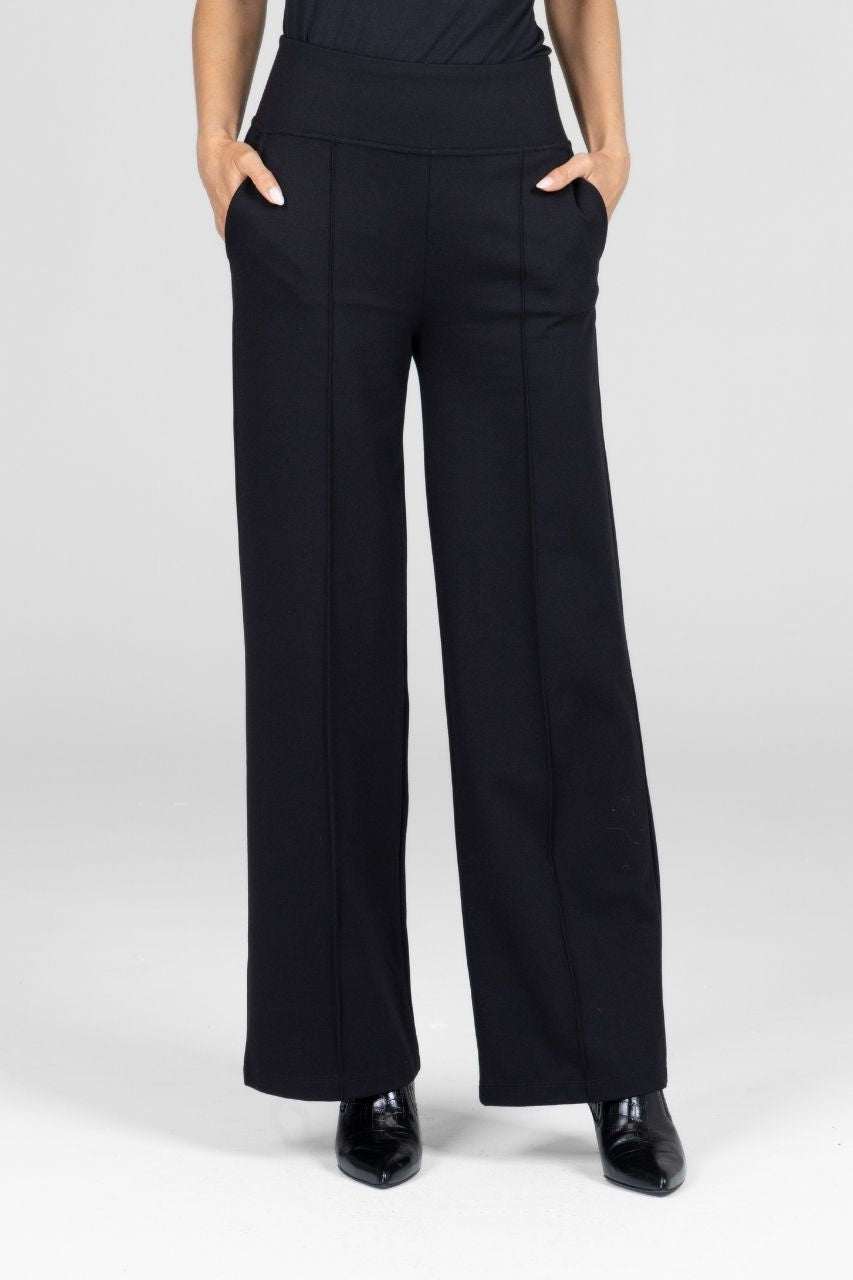 Woman wearing black high-waisted wide leg pants with pintucks on a white background