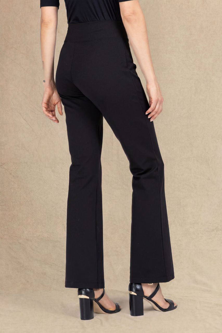 Back view of a woman wearing black micro flare pants on a beige background
