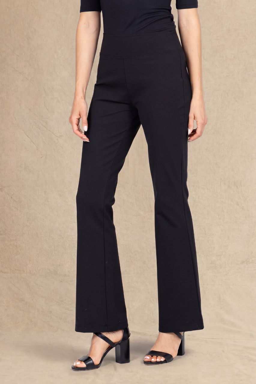 Woman wearing black micro flare pants on a beige background