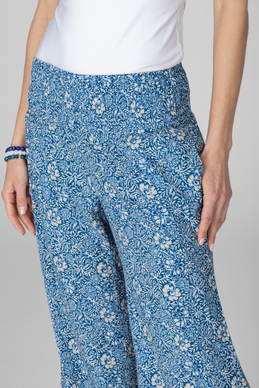 Close up of woman wearing blue batik printed portofino pant with smocked high rise waistband