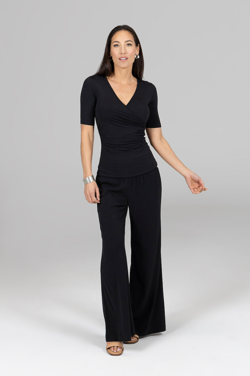 Woman wearing short sleeve v-neck top with black wide leg pants