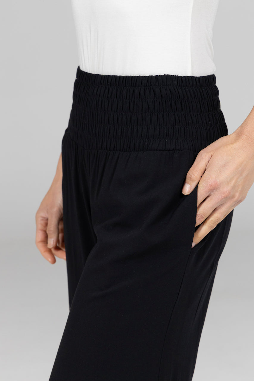 Close up of woman wearing high waisted pants with smocked waistband