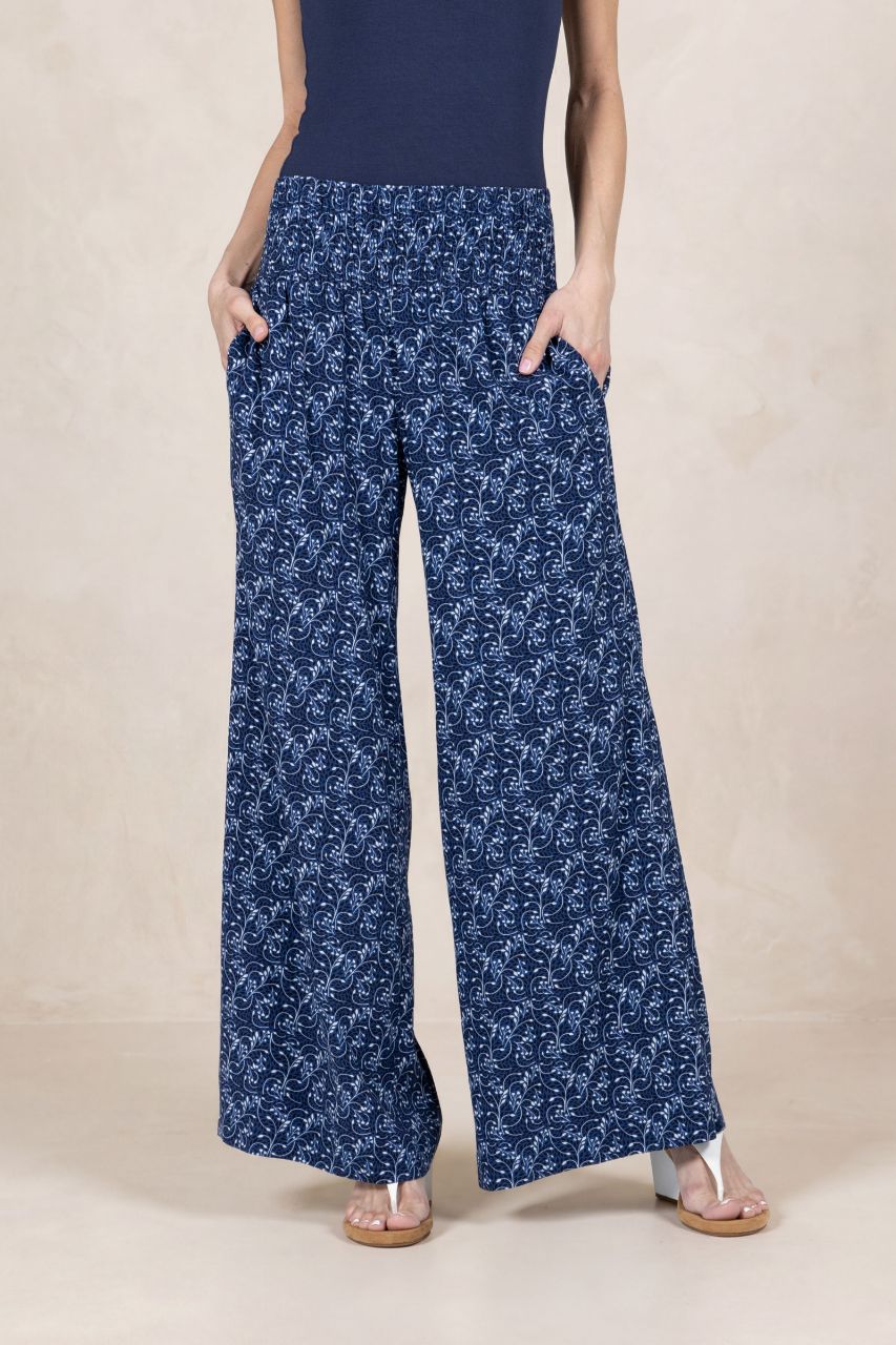 Person wearing blue floral wide-leg pants on a beige background