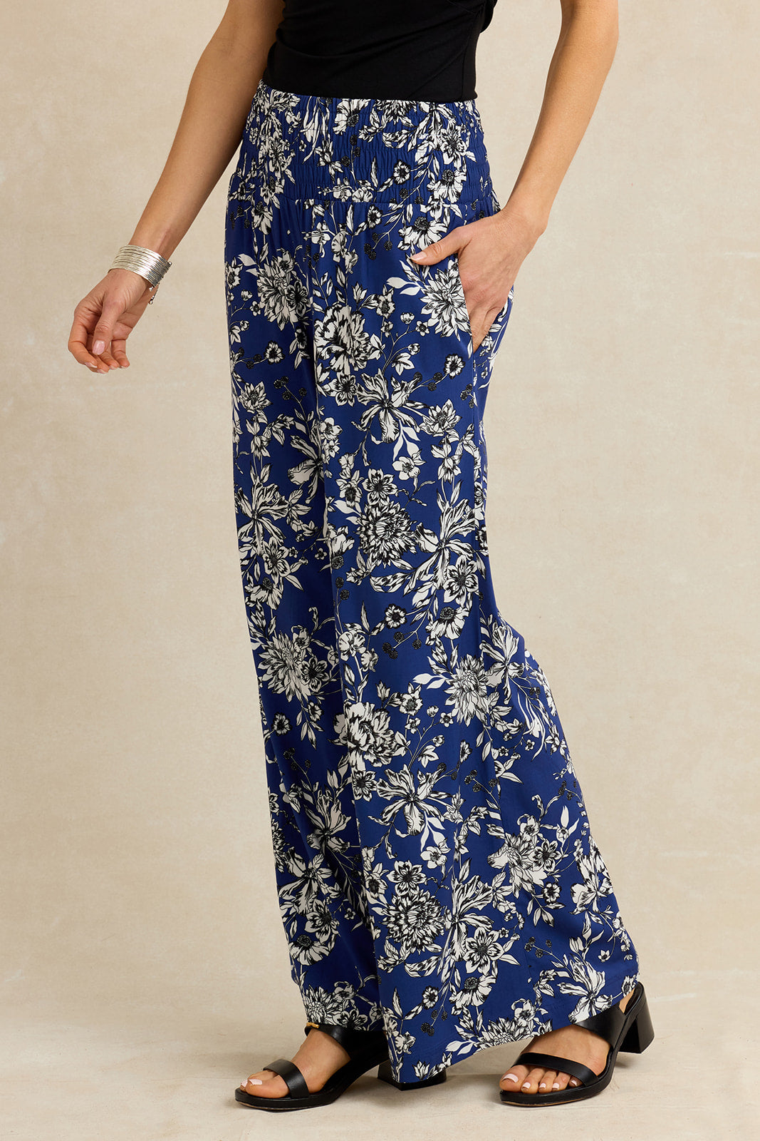 Person wearing blue floral pants on a beige background