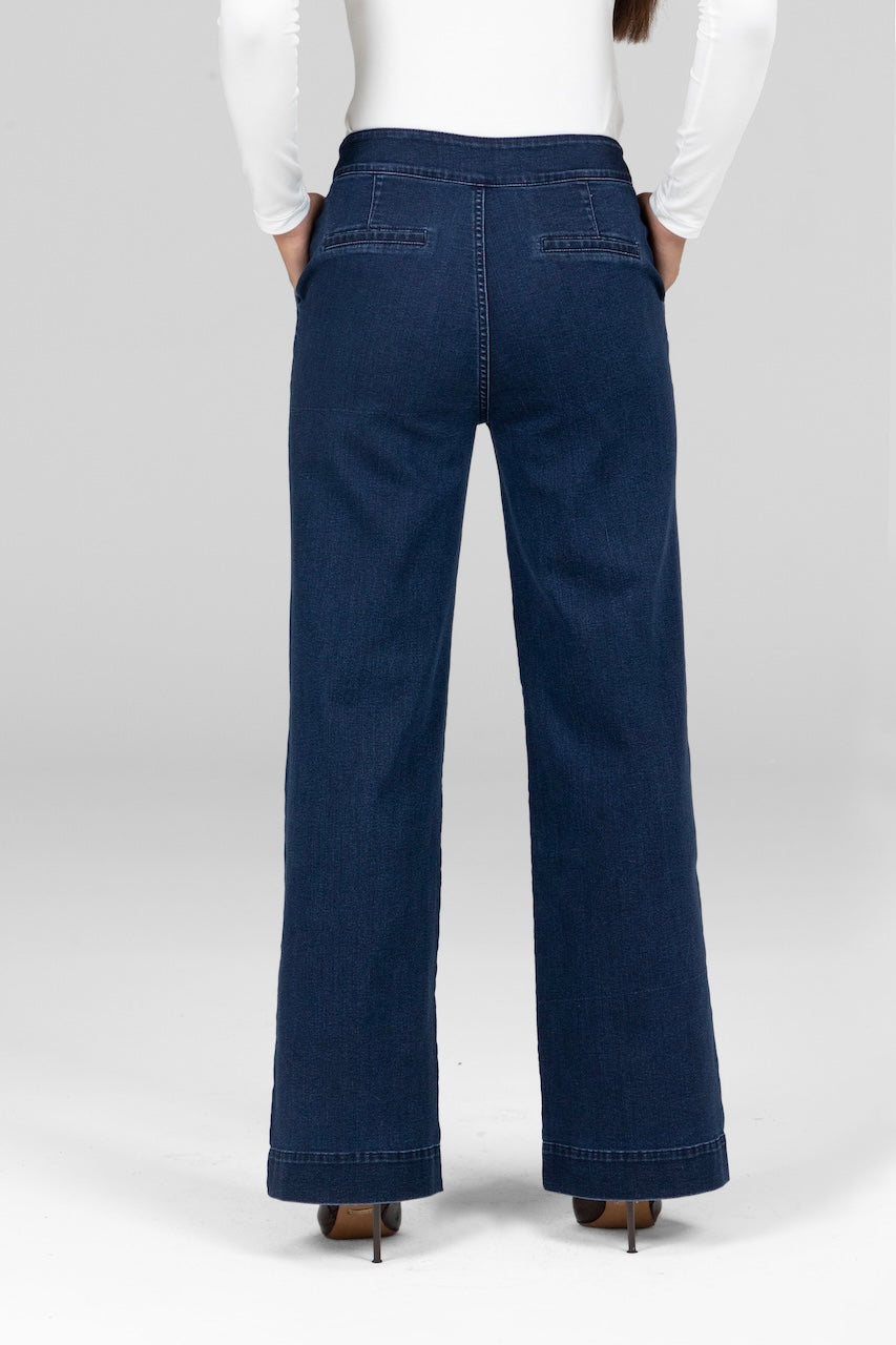 Back view of woman wearing dark wash stretch denim trousers with wide leg