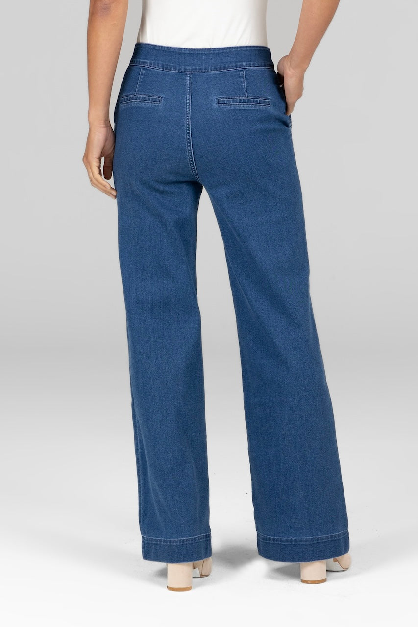 Back view of woman wearing light blue stretch denim trousers with wide leg