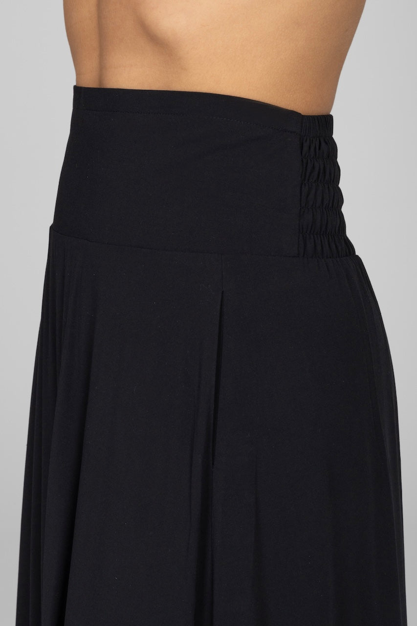 Close up view of woman wearing a black maxi skirt with smocked waistband