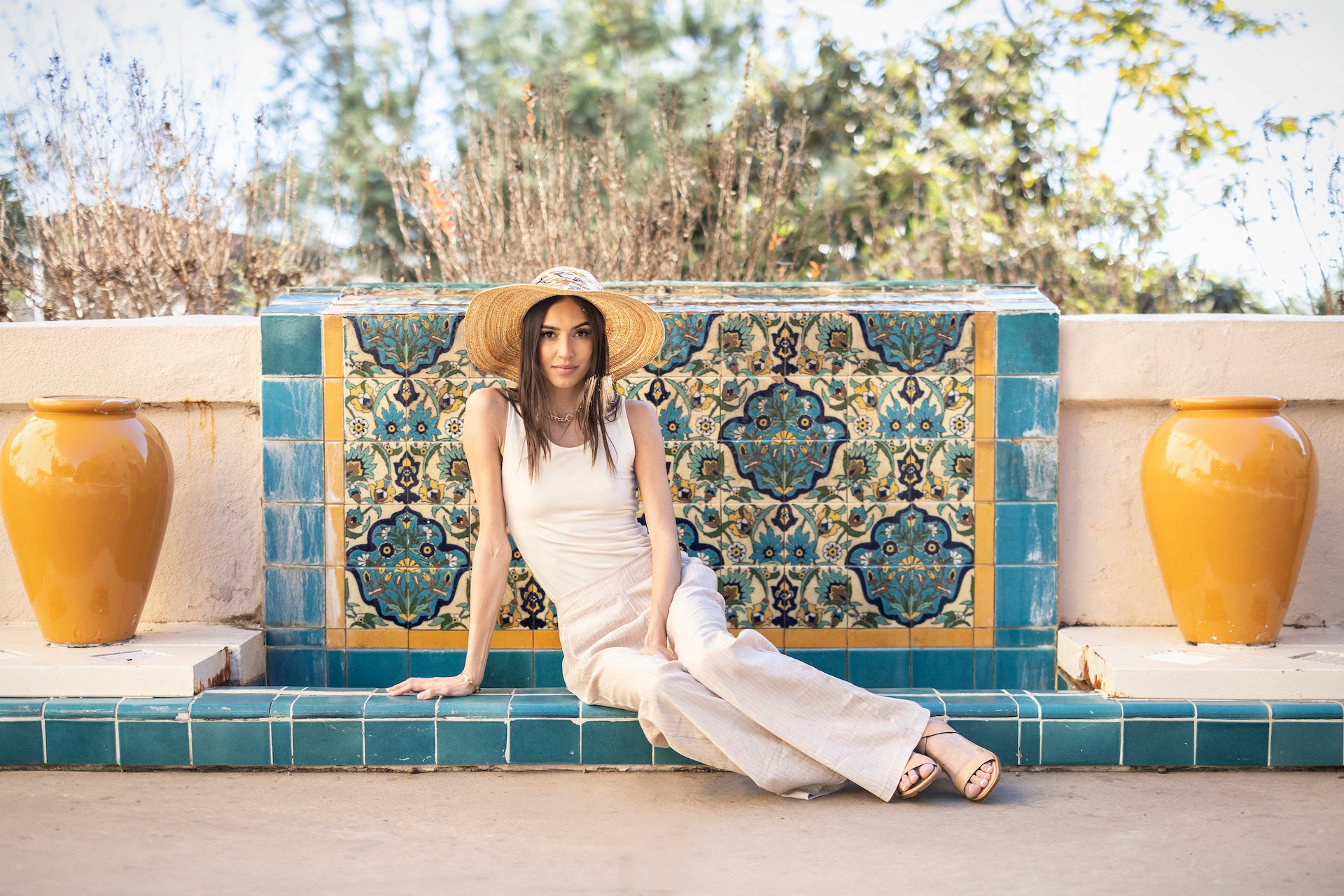 Model in a sitting pose wearing the Roslyn Tank in ivory, highlighting the relaxed fit and elegant design that creates a sophisticated yet comfortable look.