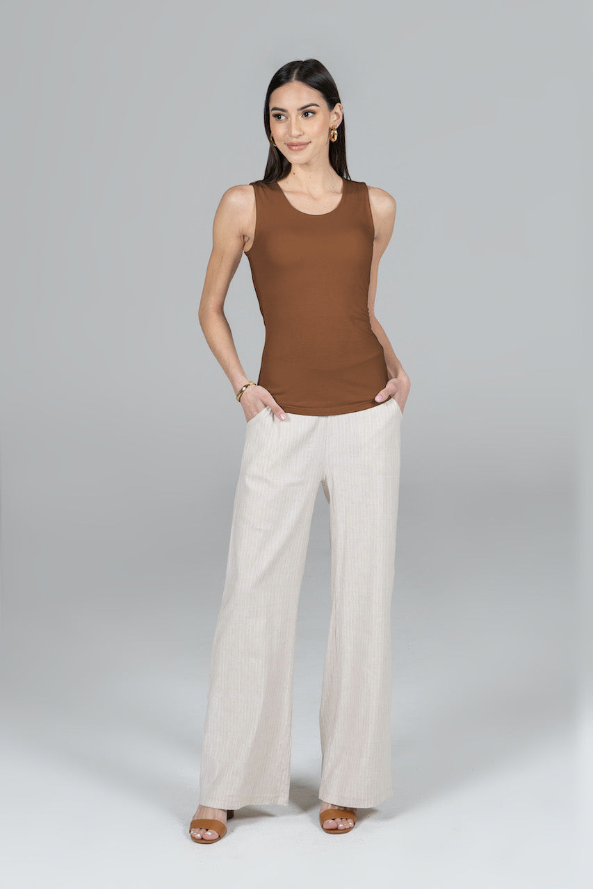 Full outfit view of the Roslyn Tank in bronze paired with white pants, showcasing the complete look.