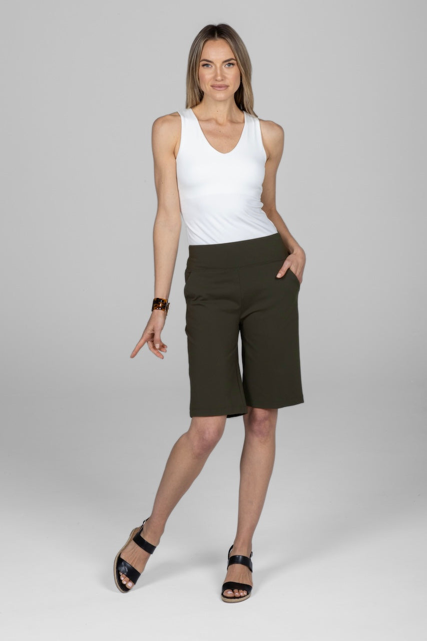 Full length outfit of woman wearing white v-neck tank top and green knee length shorts