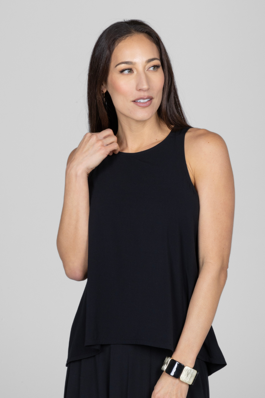A woman wearing a black sleeveless top with a round neckline and a relaxed fit.