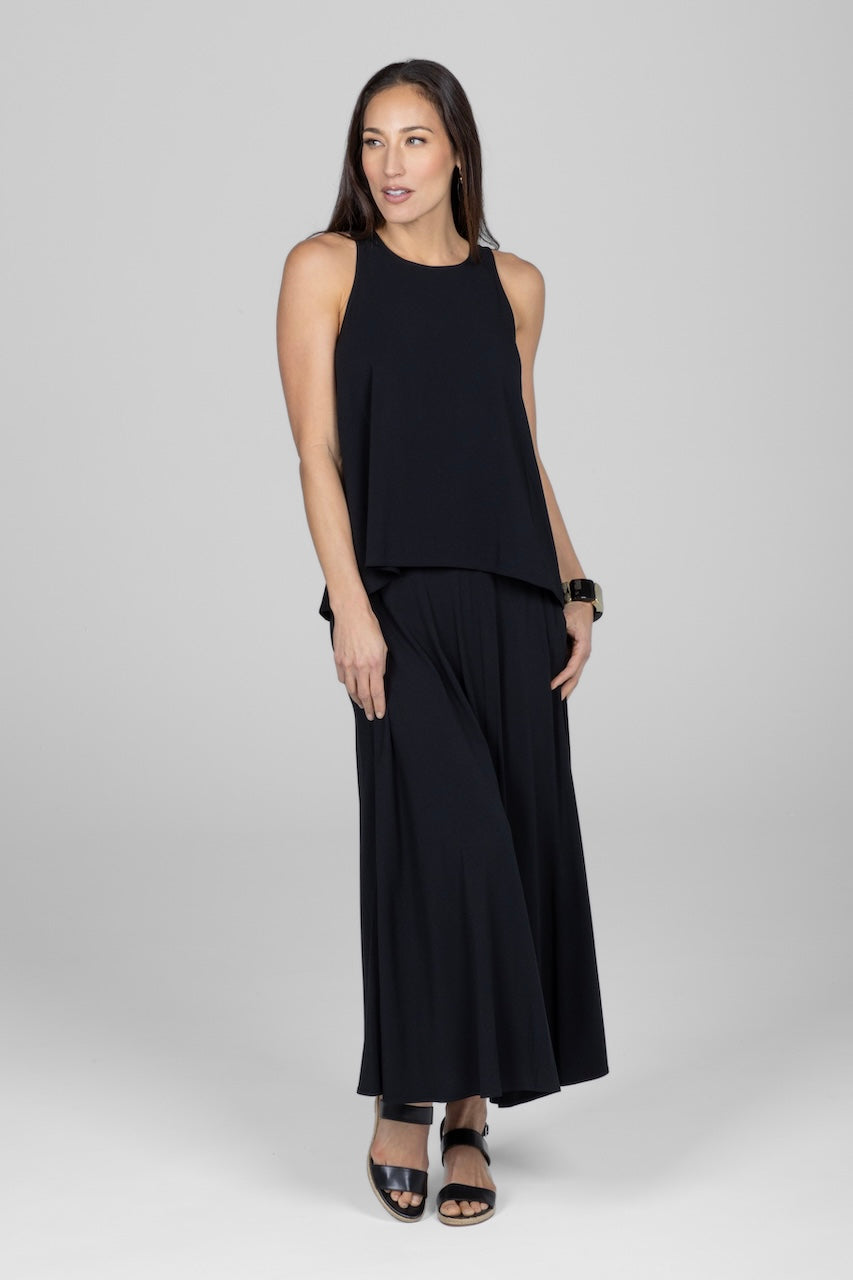 Woman wearing black sleeveless flowy top with matching maxi skirt