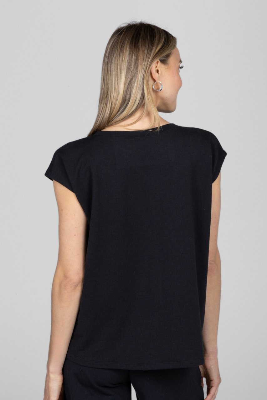 A woman facing away from the camera wearing a black short sleeve dolman top