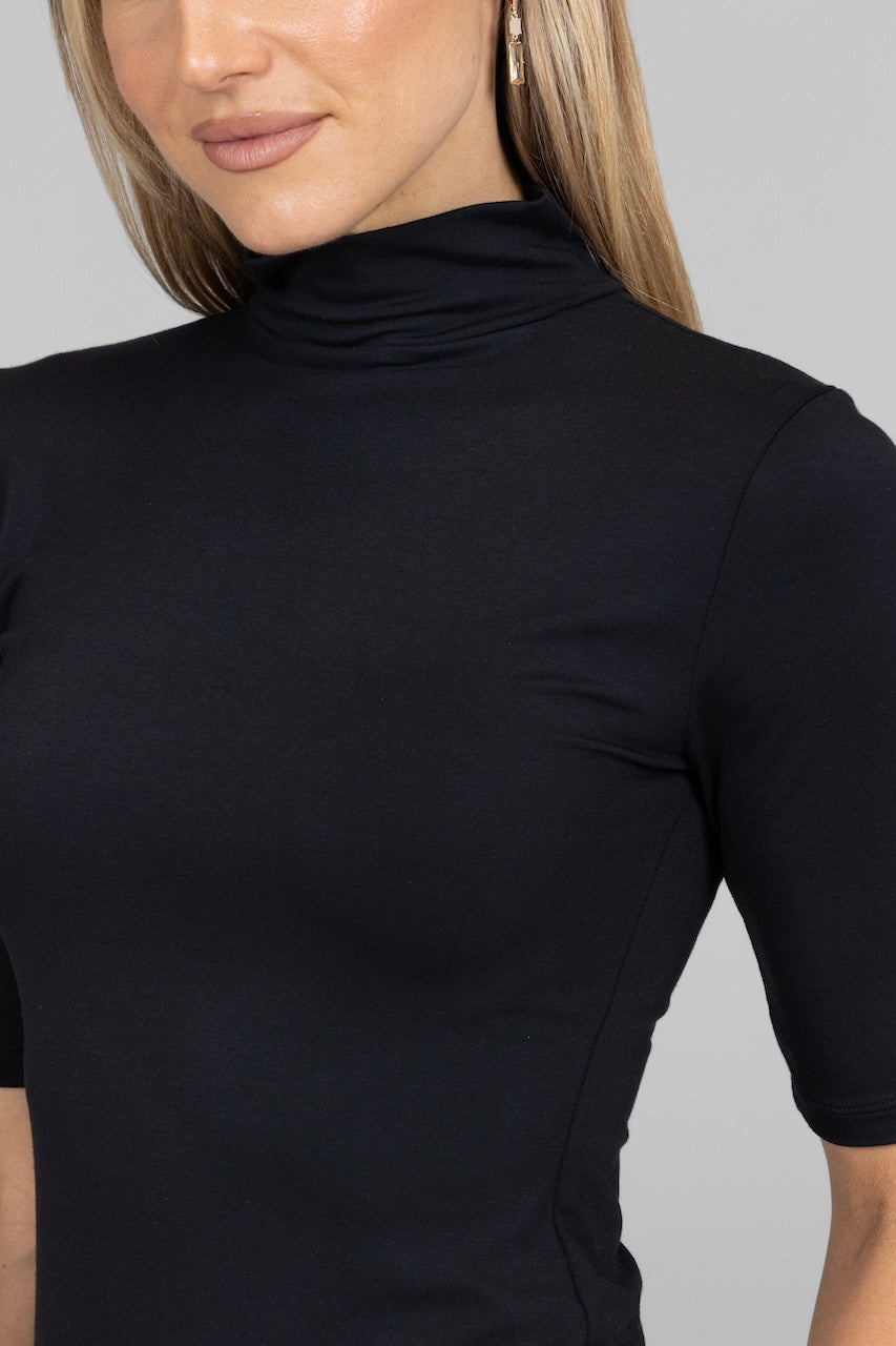 Close up of a woman wearing a black mockneck tee