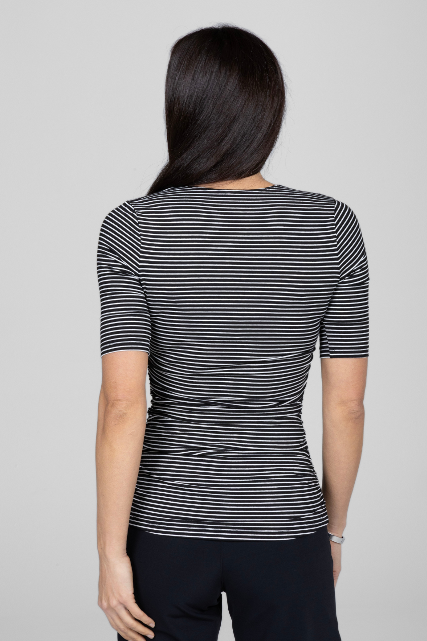 Back view of woman wearing black and white striped short sleeve top with ruching