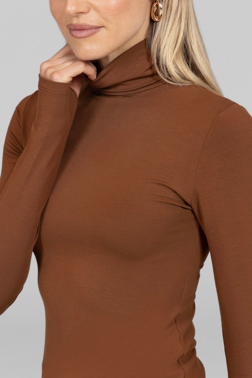 Close-up of the bronze Grace Turtleneck, showcasing the smooth fabric and turtleneck collar.