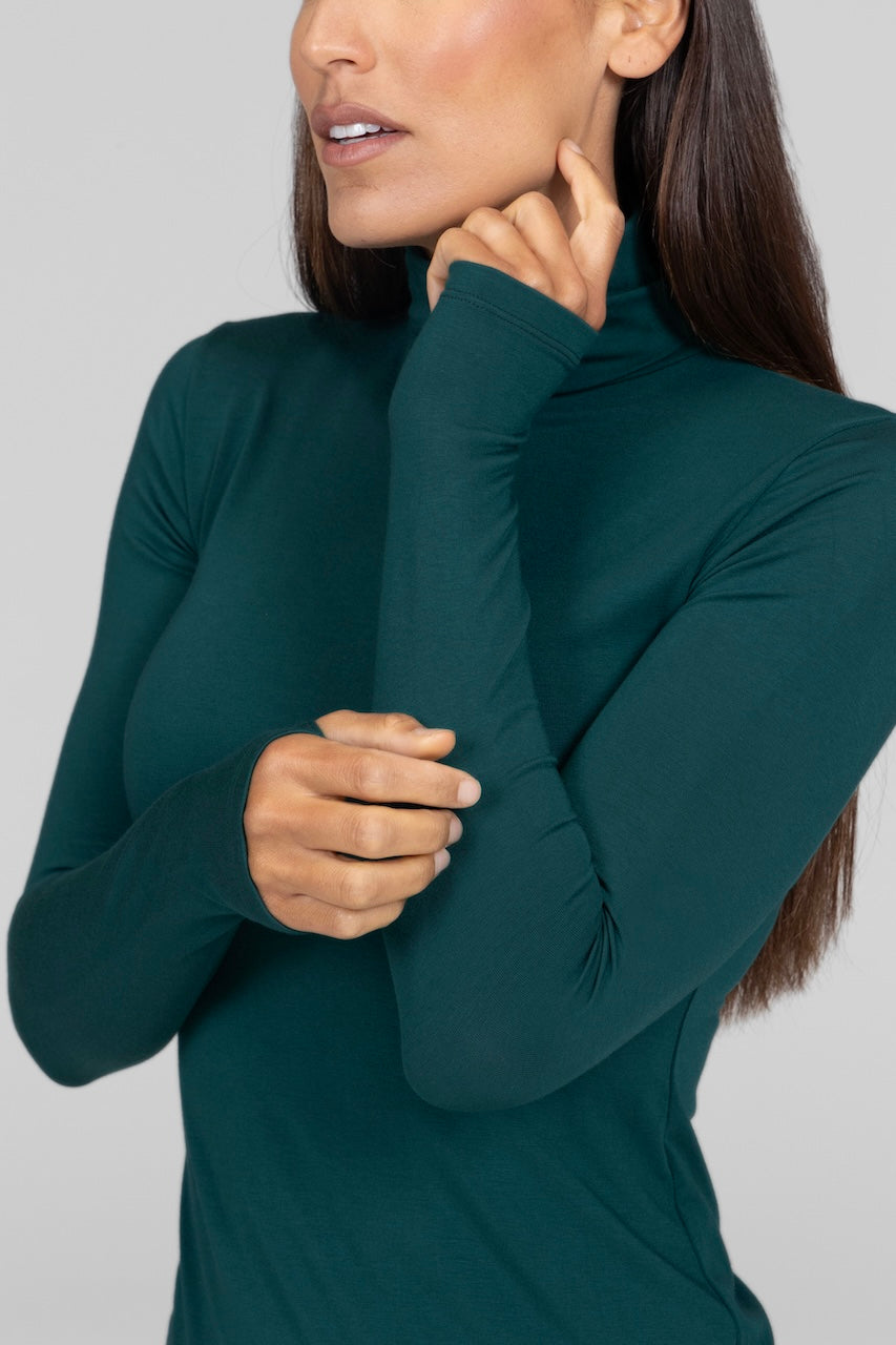 Close-up of the emerald Grace Turtleneck, showcasing the rich fabric texture and refined turtleneck collar.